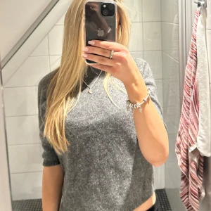 Grå stickad tröja från Zara - Säljer denna superfina stickade, kortärmade tröja från zara!!🥰🥰sparsamt använd och i väldigt fint skick💕