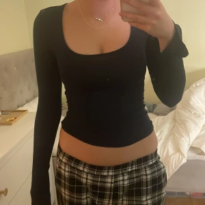 Mörkblå långärmad topp från Gina Tricot - Snygg mörkblå långärmad topp från Gina Tricot i en mjuk och stretchig bomullsmix. Perfekt för lager-på-lager eller som den är. Rund halsringning och figurnära passform.