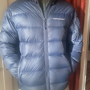 Blå dunjacka från Peak Performance - Säljer en blå dunjacka från Peak Performance. Inköpt höst 2023. Använd 1 säsong. Varm, riktigt dun.
