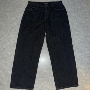 Svarta baggy jeans - Svarta baggy jeansbyxor från Decade med klassisk femficksdesign. Byxorna har en baggy passform och är perfekta för en avslappnad stil. De är tillverkade i ett slitstarkt denimtyg som ger en tidlös look.