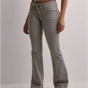 Nelly jeans  - Snygga grå bootcut jeans med låg midja som inte säljs längre! Säljer för att dem blivit för korta. Enda ”defekten” på jeansen är att jag sprättat upp sömmen längst ner så att dem skulle bli längre vilket gjort att dem har repats upp längst ner. Pris kan diskuteras! Nypris: 699 kr 