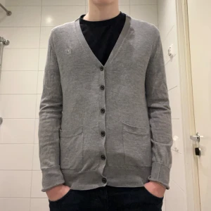 Tiger of Sweden Cardigan - Säljer denna gråa Tiger of Sweden Cardigan i storlek S| Jag på bilden är 172cm lång men den är liten på mig| Skick: 9/10( Inga tecken på användning)| Kontakta vid minsta lilla fråga eller fundering.