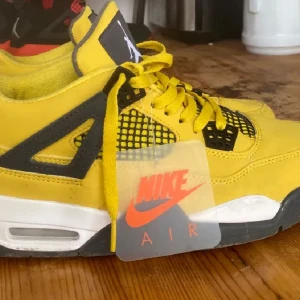 Gula Nike Air sneakers - Snygga gula Nike Air sneakers med svart och vit sula. Skorna har snörning och en ikonisk design med synlig Air-enhet i hälen. Perfekta för dig som vill sticka ut med en färgglad stil!