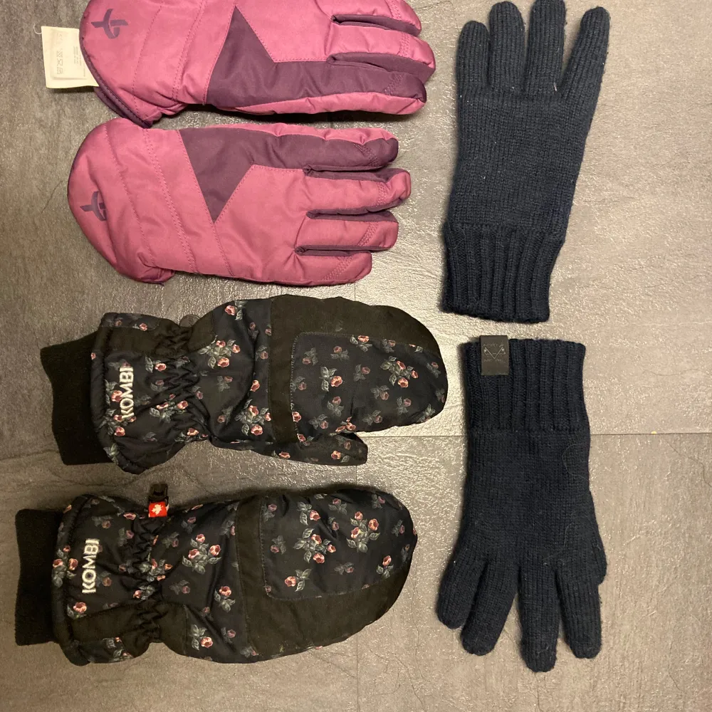 Säljer tre par vintervantar: ett par svarta vantar med blommönster från Kombi, ett par lila och svarta handskar med justerbar rem, och ett par mörkblå stickade handskar. Perfekta för kalla dagar!. Asusteet.