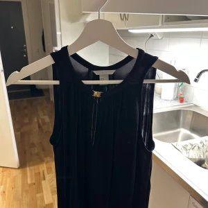 Svart ärmlös topp - Elegant svart ärmlös topp med rund halsringning. Perfekt för en stilren look. 