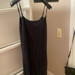 Svart klänning från Amisu - Snygg svart klänning från Amisu med smala axelband och en enkel design. Perfekt för en stilren look. Tillverkad i ett mjukt material som ger en bekväm passform.