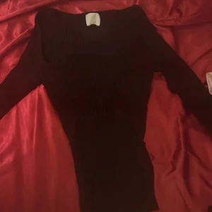 mörkröd ribbad tröja - Snygg mörkröd ribbad tröja med långärmad design. Perfekt för en stilren look och passar bra till både jeans och kjol.