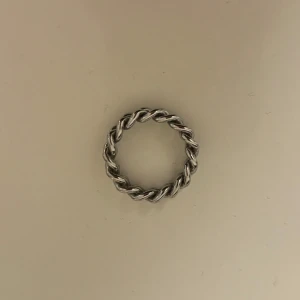 EDBLAD, Silverfärgad flätad ring - Stilren och elegant ring i silverfärg med ett flätat mönster. Perfekt för att ge en subtil men chic touch till din stil. Passar både till vardag och speciella tillfällen.