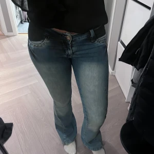 Lågmidjade bootcut jeans - Jättesnygga bootcut jeans som är väldigt lågmidjade! De har väldigt snygga bakfickor och andra detaljer framtill. De är i storleken 27 och från märket Foshi. Pris kan diskuteras!💕