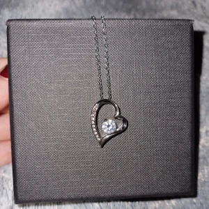 Fint halsband - Halsband med plätering i vitguld. Använt en gång. Hjärta med sten i mitten och 8 små stenar.