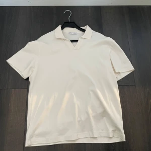 Pike - Säljer en stilren vit pikétröja från Zara med korta ärmar och klassisk krage. Perfekt för en avslappnad men ändå snygg look. Passar bra till både jeans och chinos. Den är i storlek M och har aldrig använts