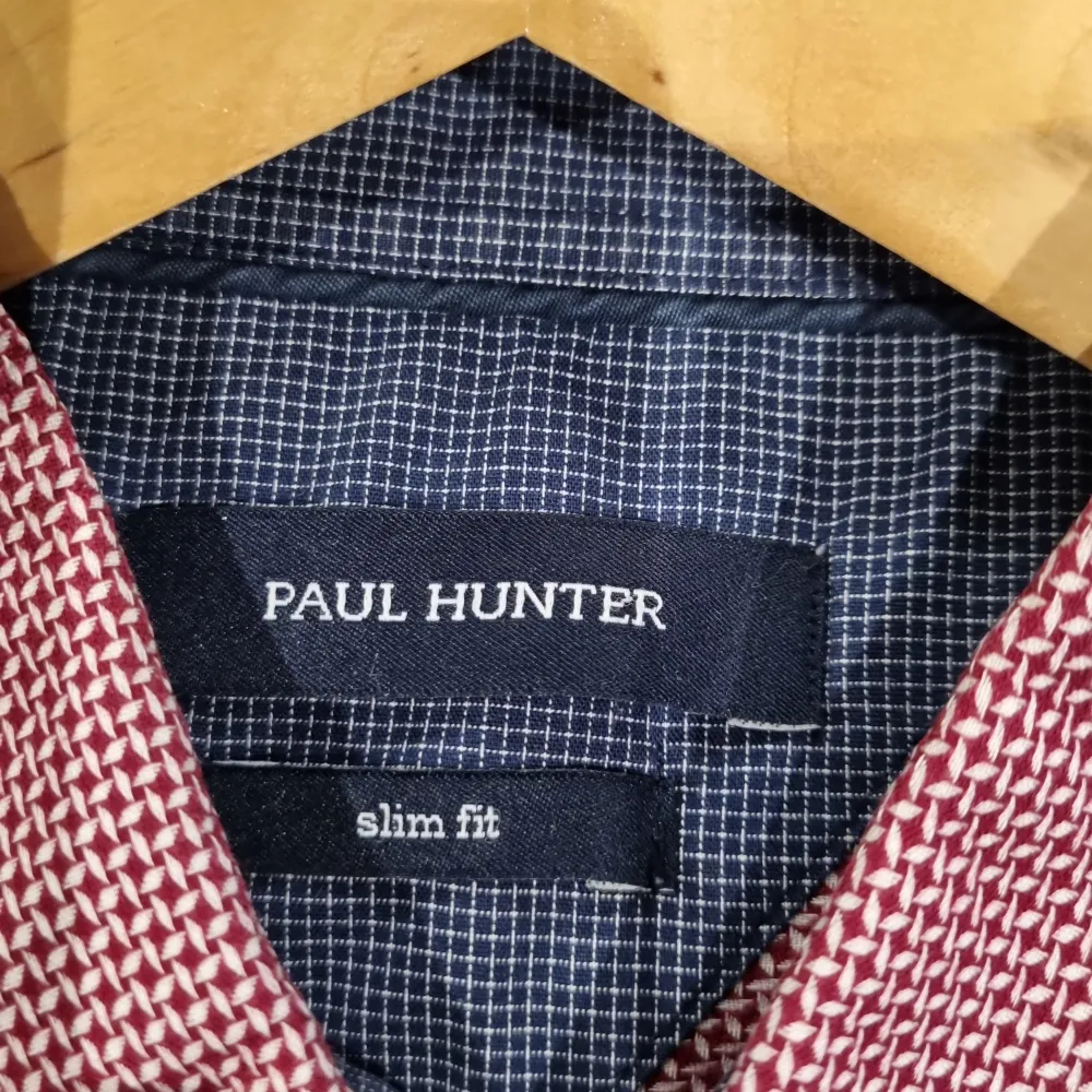 Säljer en snygg röd slim fit skjorta från Paul Hunter. Skjortan har ett diskret mönster och är långärmad med knappar fram. Perfekt för både vardag och fest! Passar bra till både jeans och kostymbyxor. Skjortan är i bra skick och redo för nya äventyr. 🕺. Skjortor.