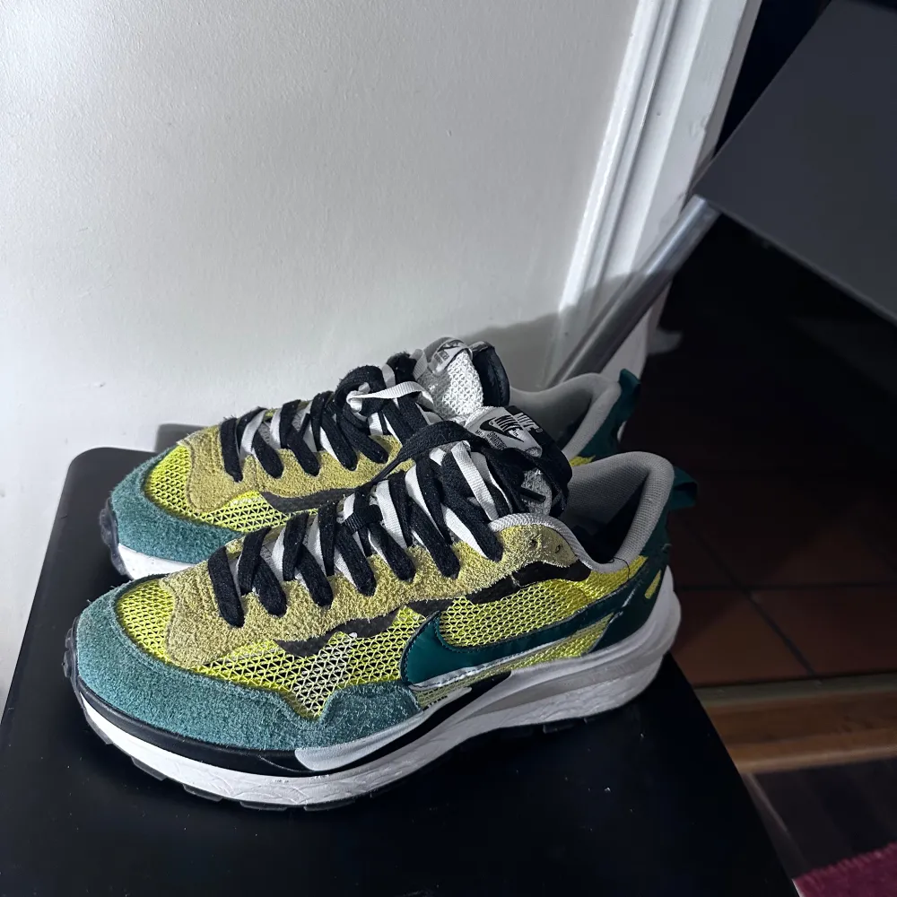 Säljer ett par unika Nike sneakers i grönt och gult med svart snörning. Skorna har en cool, flerdimensionell sula och är perfekta för både vardag och träning. De är i bra skick och redo för nya äventyr. Passar perfekt för dig som vill sticka ut med stil!. Skor.