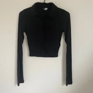 Jet black top med krage - Stretchig, skön och sexig. Skulle passa bra till svart halloween outfit