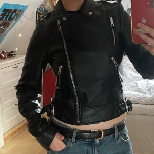 Svart Läderjacka - En svart tight läderjacka (inte äkta läder) från Zara! Använd några gånger men har inga skador. Perfekt til hösten och är i storlek S men passar också som XS! 