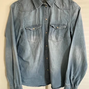 VILA Skjorta viBista Denim Shirt - Small i storlek DENIM JEAN SKJORTA I UTMÄRKT SKICK I Medium blue denim.