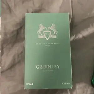 Säljer en lyxig parfym från Parfums de Marly, Greenley. Flaskan är elegant grön med en silverfärgad kork och rymmer 125 ml. Perfekt för den som vill ha en fräsch och sofistikerad doft. Kommer i originalförpackning.