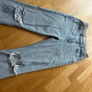 Ljusblåajeans med hål - Ljusblåajeans med hål på båda knäna. Liten slits på båda benens innersida. Fint skick! Köp pris: 200 kr Säljprojekt: 90 kr