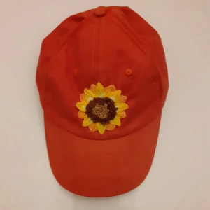 Broderad keps - Söt keps som jag har broderat en fin solros på! Står Kappahls logga på spännet 