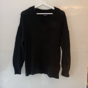 Svart stickad tröja från Gina Tricot - Mysig svart stickad tröja från Gina Tricot i storlek S, den är overside i modellen. Perfekt för kyliga dagar med sin varma och bekväma passform. Tröjan har en v-ringad hals och långa ärmar, vilket gör den idealisk för både vardag och mysiga hemmakvällar💕🍂