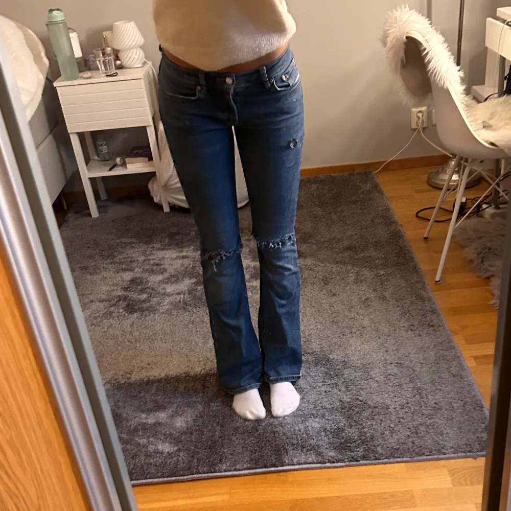 Säljer dessa mörkblåa lågmidjade jeansen med hål/slitningar som är köpta på plick. Storlek Xs/34 passar mig som är 165 cm. Jättefint skick!❣️. Jeans & Byxor.