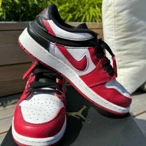 Nike Air Jordans i rött, vitt och svart - Säljer ett par snygga Nike Air Jordans i klassiska färgerna rött, vitt och svart. Skorna har en cool design med snörning och är perfekta för både vardag och fest. De är i nyskick och redo att bäras av någon som älskar stil och komfort.