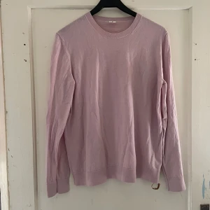 Ljusrosa tröja i bomull - Säljer en superfin ljusrosa tröja i bomull. Den är långärmad och perfekt för både vår och höst. Tröjan har en enkel och stilren design med ribbade muddar vid ärmslut och nederkant. Perfekt för en avslappnad look! 🌸