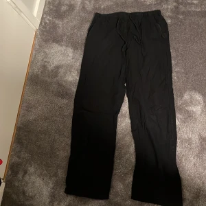 Svarta sommarbyxor - Säljer ett par svarta sommarbyxor gjorda  av bomull och linne. Perfekta för en varm sommardag när man ska ut och äta glass. Byxorna har en loose passform med snören istället för en resor eller bälte. Ett måste i garderoben för alla som älskar värme och sol!