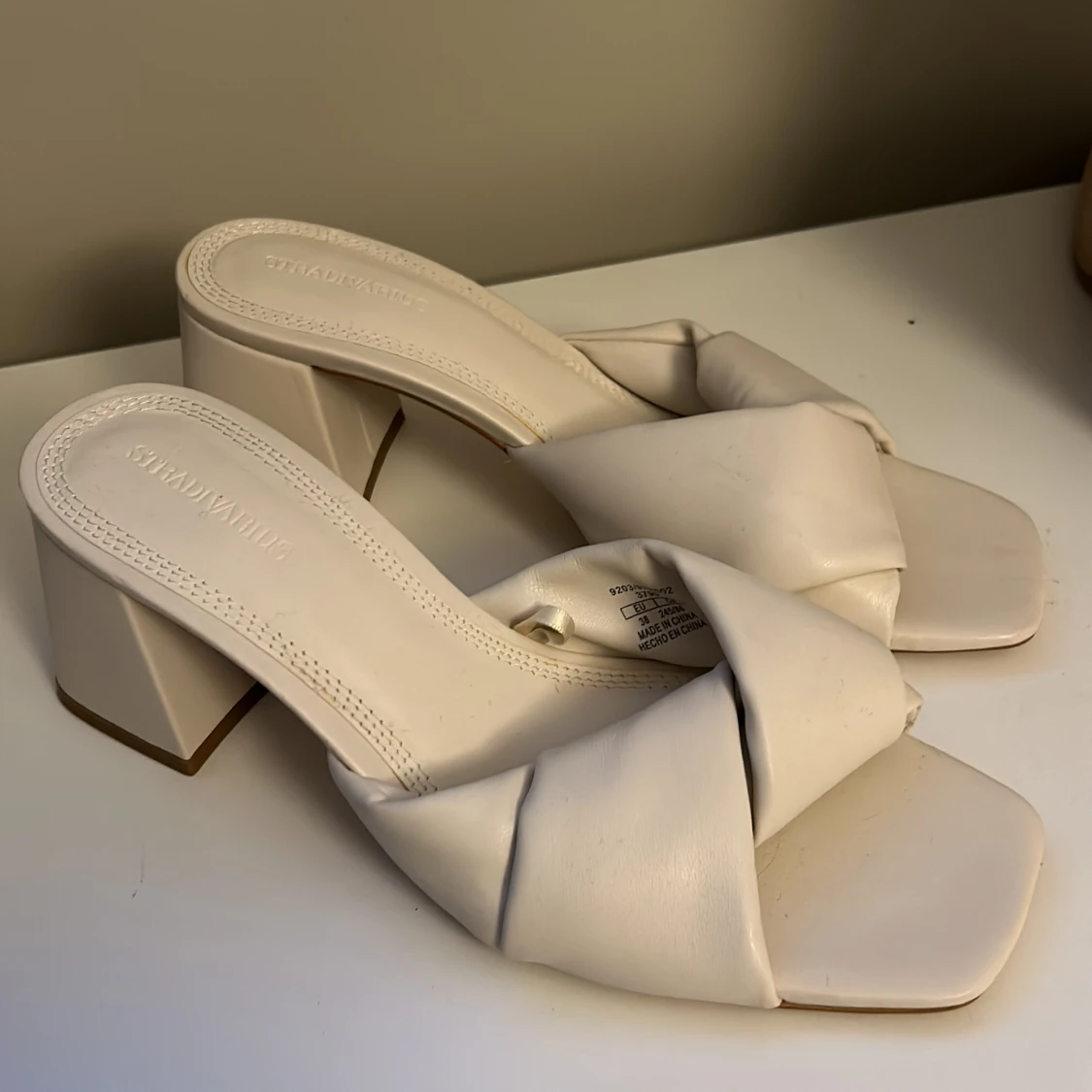 Vita klackskor med knutdetalj