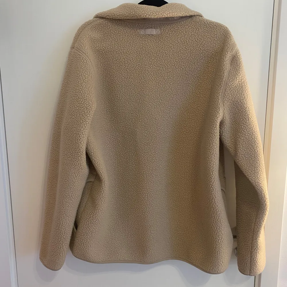 Säljer en supermysig beige teddyjacka från H&M i storlek L. Den har en dragkedja framtill och är perfekt för kyliga dagar. Jackan är i regular fit och passar både till vardags och lite mer avslappnade tillfällen. Den är i bra skick och väldigt bekväm att ha på sig💗. Jackor.