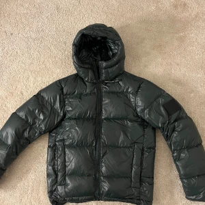 Grön dunjacka - Tjock mörkgrön dunjacka från Peak Performance i strl L