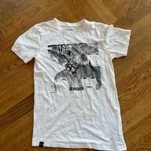 T-shirt - Vit t-shirt med tryck av the Beatles album revolver.