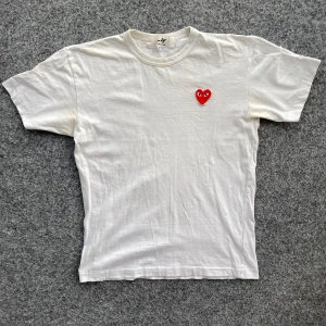 Commes des garcons t-shirt - Comme des Garçons PLAY T-Shirt. Asfet. Storlek: S-M eftersom den har krymps efter första tvätten då tshirten är producerad i otvättad bomull. Finns lätt missfärgning vid armhålorna. Bra skick överlag. Hör av er vid eventuella frågor!!