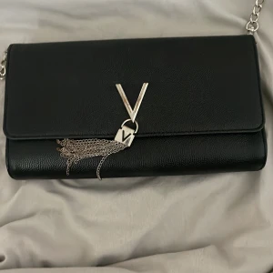 Valentino väska  - Köpte den för drygt ett år sedan använd ett fåtal gånger då jag it gillar den längre. Har bara legat i en låda och har därför börjat tappa lite färg vid märket. Fler bilder kan man be om även pris kan diskuteras köpt för 929kr( priset går att diskutera vill bara bli av med den)