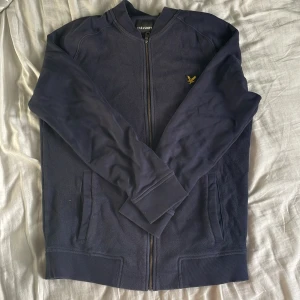 Lyle&scott tröja - En lyle&scott marinbkå fullzip. Tröjan är i bra skick utan några defekter.priset kan diskuteras.