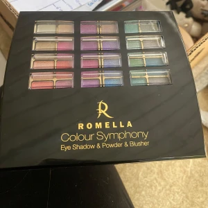 Romella Colour Symphony Palette - Färgsprakande sminkpalett från Romella med ögonskuggor i regnbågens alla färger samt puder och rouge. Perfekt för att skapa både dramatiska och naturliga looks. Paletten innehåller nyanser i rosa, lila, blått, grönt och neutrala toner. Har provat vissa färger och borstarna är borta, men inget mer än så☺️