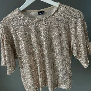 glittrig topp  - Säljer en snygg glittrig topp från Gina tricot.