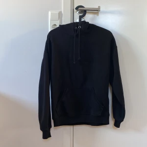 Svart hoodie från BikBok - Säljer en klassisk svart hoodie från BikBok i storlek XS. Den har en praktisk magficka och justerbar huva med dragsko. Perfekt för en avslappnad stil.