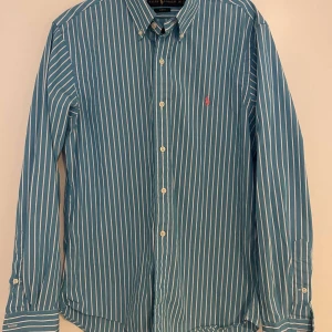 Ralph Lauren Skjorta - Säljer en riktigt snygg blå och vit randig skjorta från Ralph Lauren som passar riktigt bra till sommaren. Mitt pris är 399 men inte ristat i sten😀