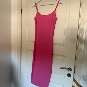 Rosa ribbad klänning - Säljer en snygg rosa ribbad klänning med smala axelband. Klänningen har en enkel och stilren design.