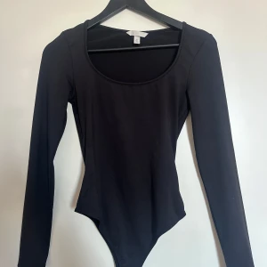 Svart långärmad bodysuit - Svart långärmad body, string med rund halsringning. Nopprig