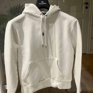 Vit hoodie från Ralph Lauren - Tjena! Säljer mitt andra exemplar av en stilren vit hoodie från polo Ralph Lauren, Skick: 10/10 ungefär helt oanvänd, blev kort på mig efter nån vecka. Nypris:1995kr. Storlek M. Säljs för 850kr vilket är ett väldigt bra pris för de skicket. Tveka inte om att höra av dig. Mvh Kevin. 