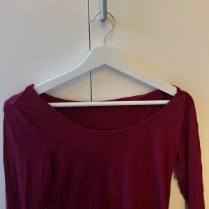 Vinröd långärmad topp - Säljer en stilren vinröd långärmad topp med en bred halsringning. Perfekt för både vardag och speciella tillfällen. Passar bra till jeans eller kjol. Skriv vid intresse eller flera frågor 