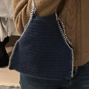 Blå virkad axelväska med kedja - En jättesnygg virkad Stella McCartney väska som jag har virkat själv  Passar perfa till en ute kväll och man får med riktigt mycket i den!! Går oxå jättebra att ha till skolan!Snygg blå stickad axelväska med en cool kedjedetalj som axelrem. Perfekt för att ge din outfit en unik touch. Väskan är kompakt och lätt att bära med sig.