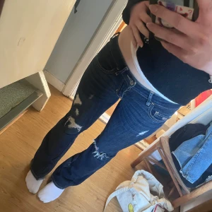 Lågmidjade bootcut jeans från hollister  - Jätte snygga lågmidjade bootcut jeans med hål i från hollister, sydda till bootcut från skinny jeans med en kil på innerbenet ( sista bilden). Skriv för mått eller andra frågor 💕