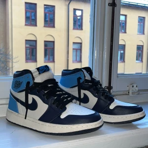 Nike Air Jordans i blått och vitt - Snygga Nike Air Jordans i en fräsch kombination av blått, vitt och svart. Skorna har klassisk snörning och en hög design som ger extra stöd. Perfekta för dig som vill ha en stilren och sportig look. Nypris ca 1500kr mitt pris 499. Inget Og ingår- kvitto, Box. Inga defekter, bara lite smuts på hälen,  (se på bild 3) Hör av er vid minsta funderingar Mvh Sigge 🥂🤙