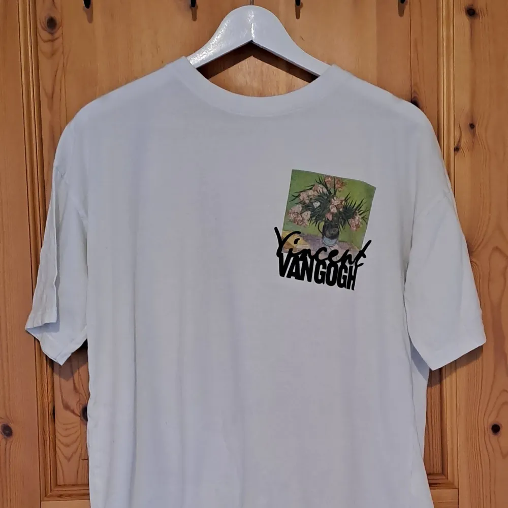 Säljer en vit t-shirt med ett coolt Van Gogh-tryck. På framsidan finns en liten bild med texten 'Vincent Van Gogh' och på baksidan ett större tryck av en av hans målningar. Perfekt för konstälskare som vill ha något unikt i garderoben!. T-shirts.