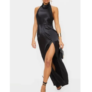 Satin maxiklänning - Maxiklänning i satin.  Köpt på prettylittlething 2020. Finns inte kvar att köpa. Hög krage med öppen rygg. Slits framtill. Väldigt fin balklänning. Endast testad, aldrig använd.  300kr inkl frakt Storlek 34 