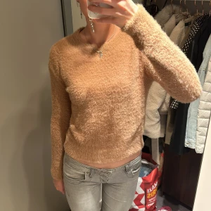 Beige fluffig tröja - Säljer en supermysig beige fluffig tröja som är perfekt för kyliga dagar. Tröjan har en normal passform och långa ärmar, vilket gör den både bekväm och stilren. Perfekt för höst och vinter!
