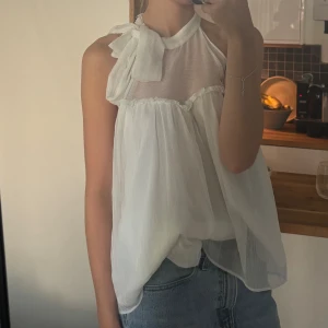 Vit topp - Kan användas som både halterneck och med ärmar. Aldrig använd och bra skick!